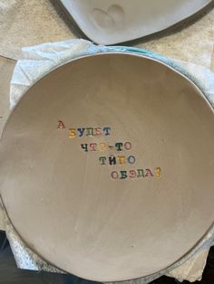 a bowl with words written on it sitting next to a white plate and napkins