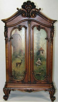 an old wooden armoire with paintings on the front and side panels, sitting next to a tall cabinet