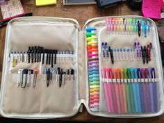 an open suitcase filled with lots of different colored pens