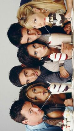 a group of young people standing next to each other in front of a white wall