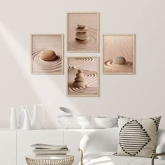 a living room with white furniture and paintings on the wall, including three stacked rocks