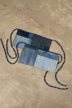 an old pair of jeans is laying on the ground with a string attached to it