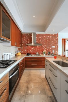 a kitchen with wooden cabinets and marble counter tops, along with stainless steel oven hoods