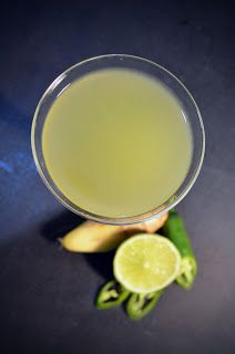 a glass filled with liquid next to some fruit