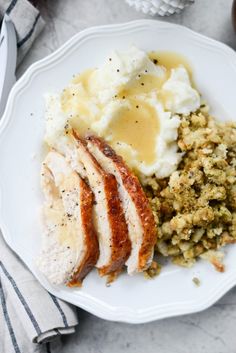 a white plate topped with meat, mashed potatoes and gravy