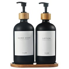 two bottles of lotion sitting on top of a wooden stand next to each other