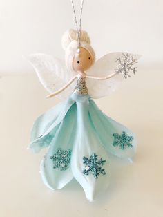 a blue and white angel ornament with snowflakes on it's wings