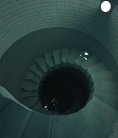 a spiral staircase in the middle of a tiled floor