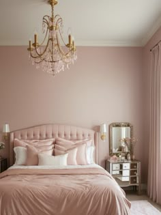 a bedroom with pink walls and a chandelier