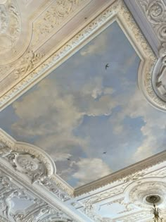 an ornate ceiling painted with clouds and birds