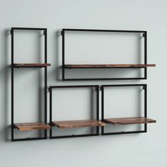 three metal shelves with wooden shelves on each side and one shelf in the middle, against a gray wall