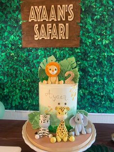 a baby shower cake with an animal theme on it's top and the name avan's safari written in large letters