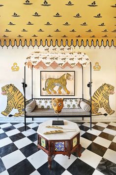 a living room with a couch, coffee table and tiger wallpapers on the walls