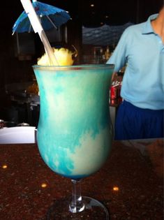 a blue drink with an umbrella in it