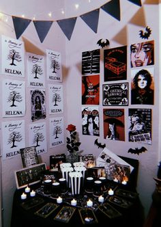 a black and white halloween table setting with candles, decorations and pictures on the wall