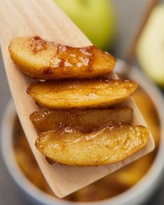 apple slices are stacked on top of each other in front of an apple and bowl