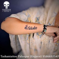 a woman with a tattoo on her arm that reads shilpota in black ink