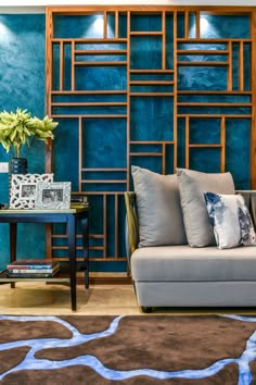 a living room with blue walls and brown rugs on the floor next to a couch