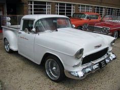 several classic cars parked in front of a building