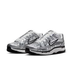 The Nike P-6000 'Metallic Silver' draws inspiration from the 2006 Air Pegasus, infusing it with futuristic flair. Its breathable metallic fabric upper features both vertical and horizontal overlays in chrome synthetic leather, creating a glistening effect. The silver side-panel Nike swoosh is outlined in black embroidery, complementing the black foxing and Nike branding on the tongue tag and heel tab. White laces match the tongue, sock liner, and insole, adorned with P-6000 branding. The comfort Nike P6000, Running Aesthetic, P 6000, Vans Top, Running Cap, Metallic Fabric, Nike Acg, Swag Shoes, Newest Jordans