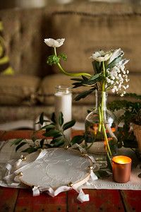 a table topped with flowers and candles on top of a wooden table