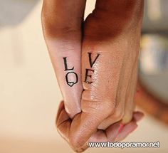 two people holding hands with the words love tattooed on their thumb and fingernails