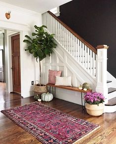 a living room filled with furniture and a large rug on top of a hard wood floor