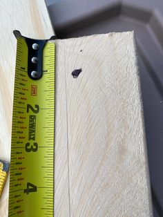 a measuring tape is next to a piece of wood