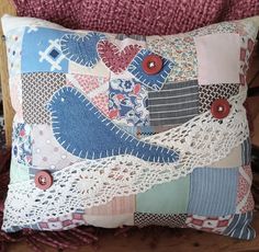 a decorative pillow with buttons and crochet lace on it sitting on a chair