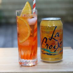 an orange drink next to a can of la croy