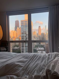 a bedroom with a large window overlooking the city