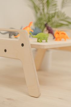 a wooden table with toy dinosaurs on it