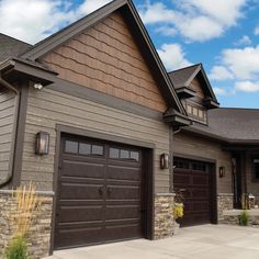 a house with two brown garage doors and windows