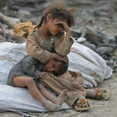 two children are sitting on the ground and one is holding his head to his ear