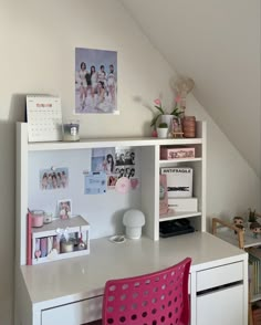 a white desk topped with a pink chair next to a book shelf