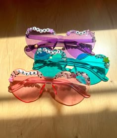 *I am open for custom or large orders just message me! Accessorize your concert outfit with these cute handmade glasses! Perfect for pictures and matching with friends. The glasses come in different designs: Speak Now, Lover, Debut, Red, 1989, Fearless and Evermore.  Please note that due to the fact that these sunglasses and handmade, no two are the same and there will be slight variation in specific color and rhinestone/bead placement. All will be very similar to the sunglasses in the photos. Taylor Swift Eras Tour Sunglasses, Eras Tour Heart Glasses, Taylor Swift Fan Outfits, Eras Sunglasses, Kidz Bop Concert Outfit, Eras Tour Outfit Inspiration Midnights, Taylor Swift Party Centerpieces, Eras Tour Inspiration, Eras Tour Outfits Inspiration