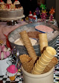 an ice cream sundae with waffle cones and other desserts on the table