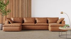 a living room with a brown leather couch and coffee table