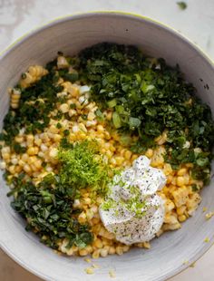 a bowl filled with corn and vegetables on top of a table