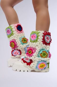 a pair of crocheted white boots with colorful flowers on the side and bottom