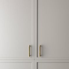 two white cupboards with brass handles on them