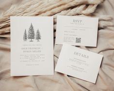 wedding stationery with pine trees printed on the front and back, sitting on a bed