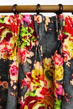 colorful floral curtains hanging on a wooden rod