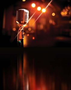 an old fashioned microphone with lights in the background