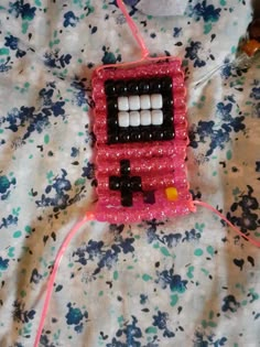 a pink and black beaded object sitting on top of a bed