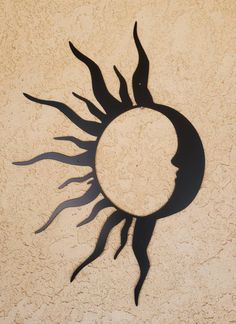 the sun is casting a shadow on the wall with it's face in the center