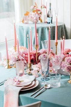 the table is set with pink flowers and candles