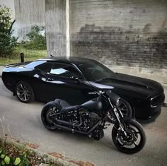 two motorcycles parked next to a black sports car