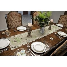 the table is set with white plates and place settings for two people to sit at