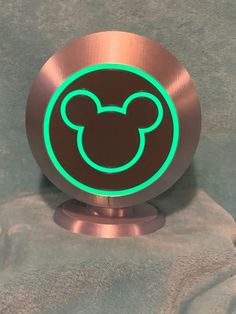 an image of a mickey mouse logo on a metal object that is glowing in the dark